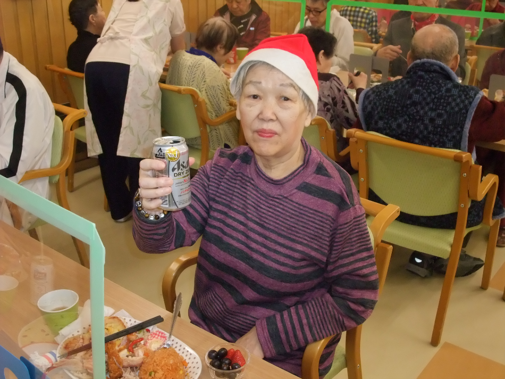 クリスマス会で提供した飲み物を片手に乾杯ポーズをとる女性
