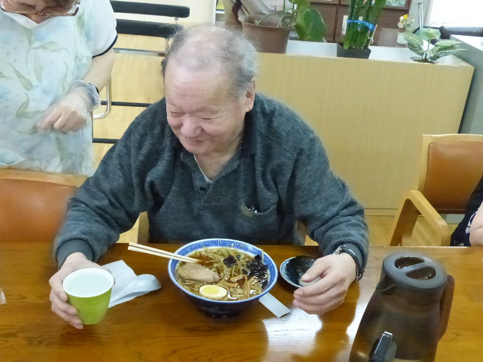 出前レクで注文したラーメンを前にする男性利用者様