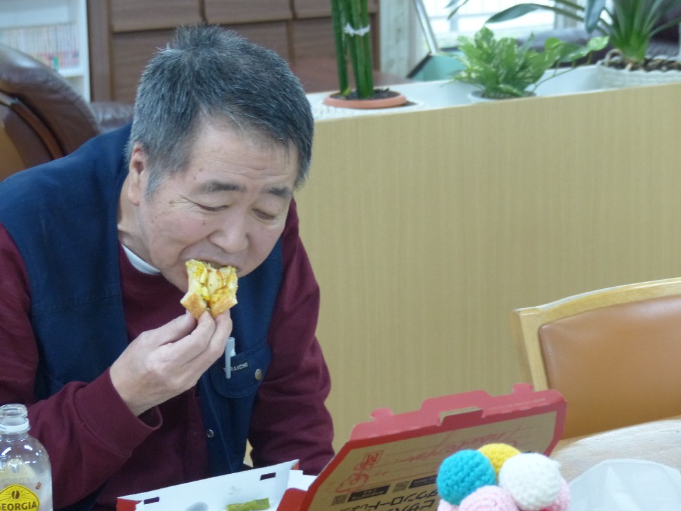 出前レクで注文したピザを食べる男性利用者様