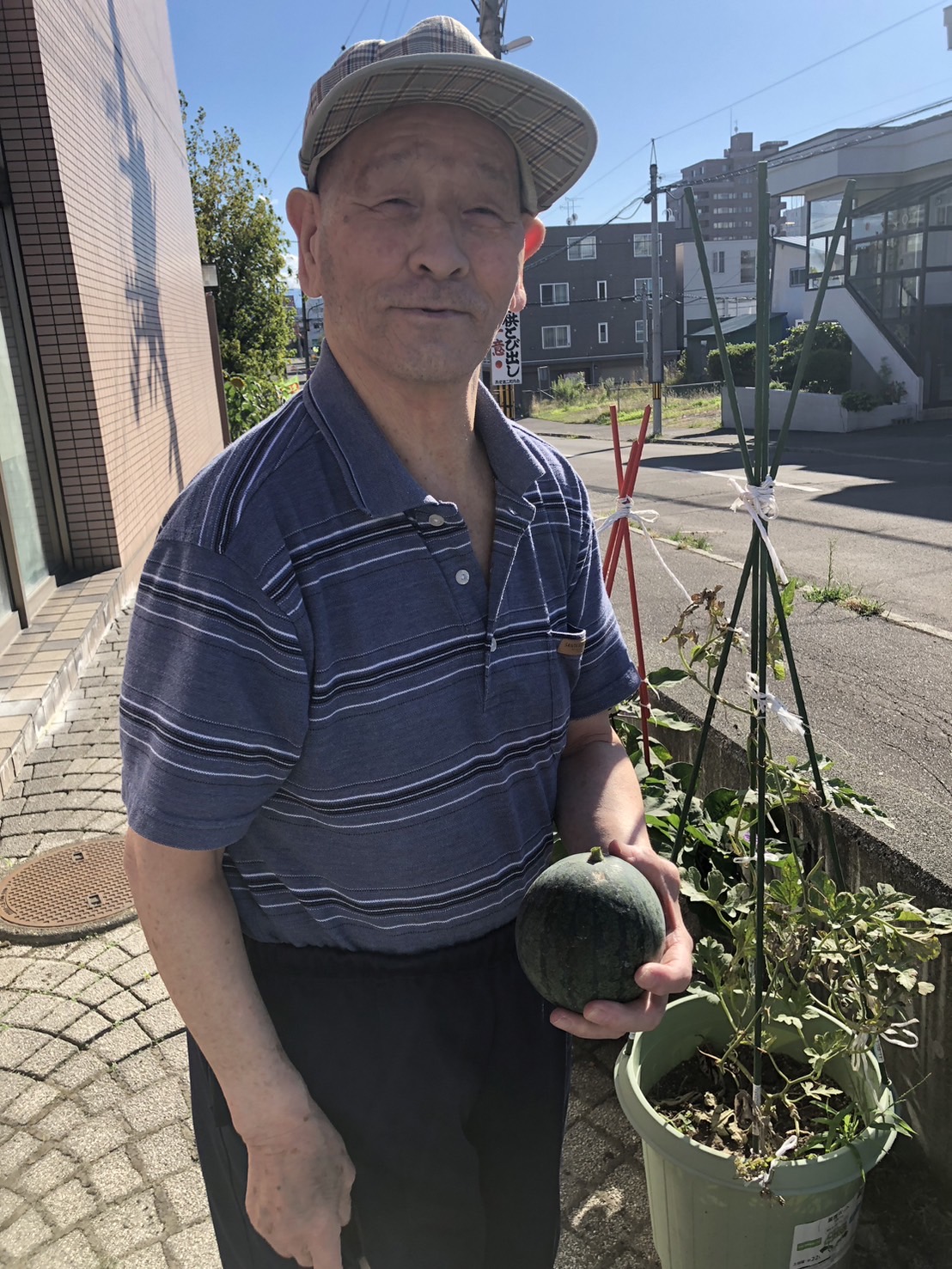 個別支援の一環としてスイカ栽培で実ったスイカを見せる男性利用者様