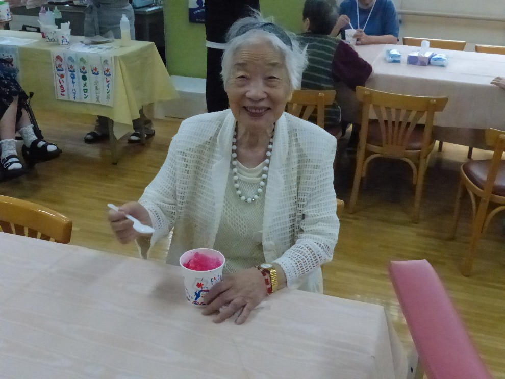 七夕祭りで選んだかき氷を食べて笑顔を見せる女性利用者様