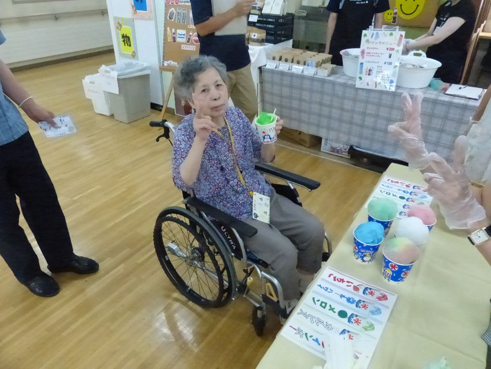 七夕祭りで選んだかき氷を手にピースサインの女性利用者様