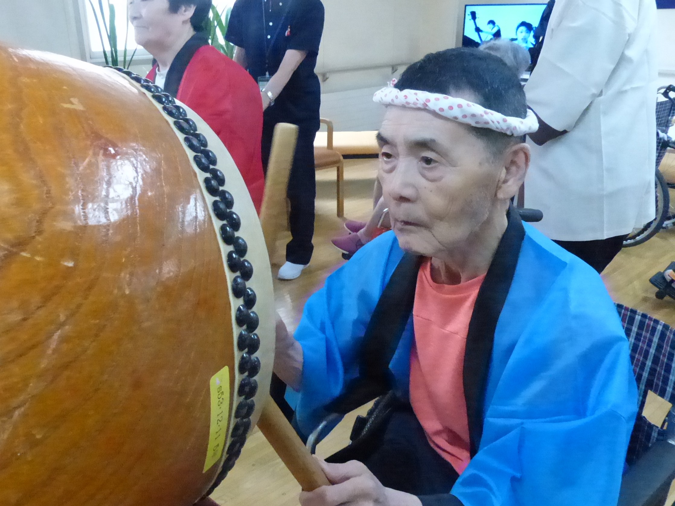 盆踊りで太鼓を叩く男性利用者様