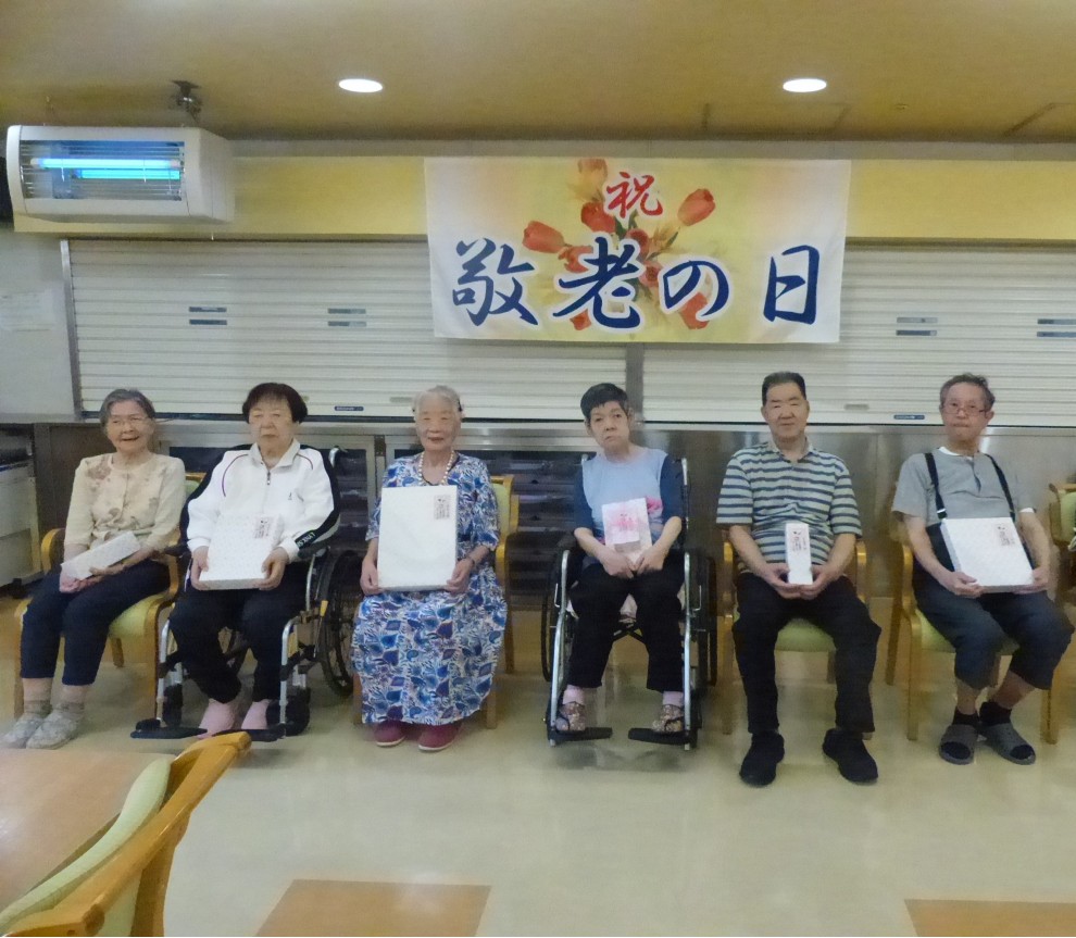 敬老会で長寿祝いを受ける利用者の皆さま
