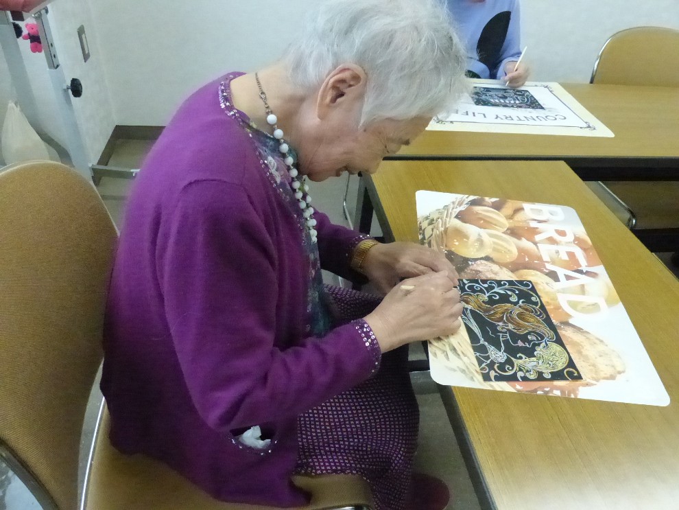 余暇クラブで笑顔いっぱいで手芸品を作成する女性利用者様