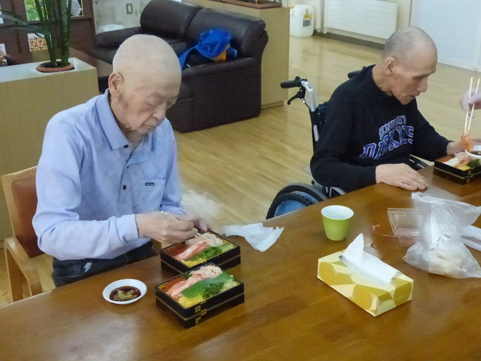 出前レクでお寿司を食べる男性利用者様