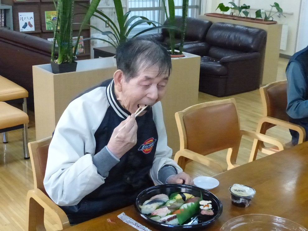 出前レクでお寿司を食べる男性利用者様