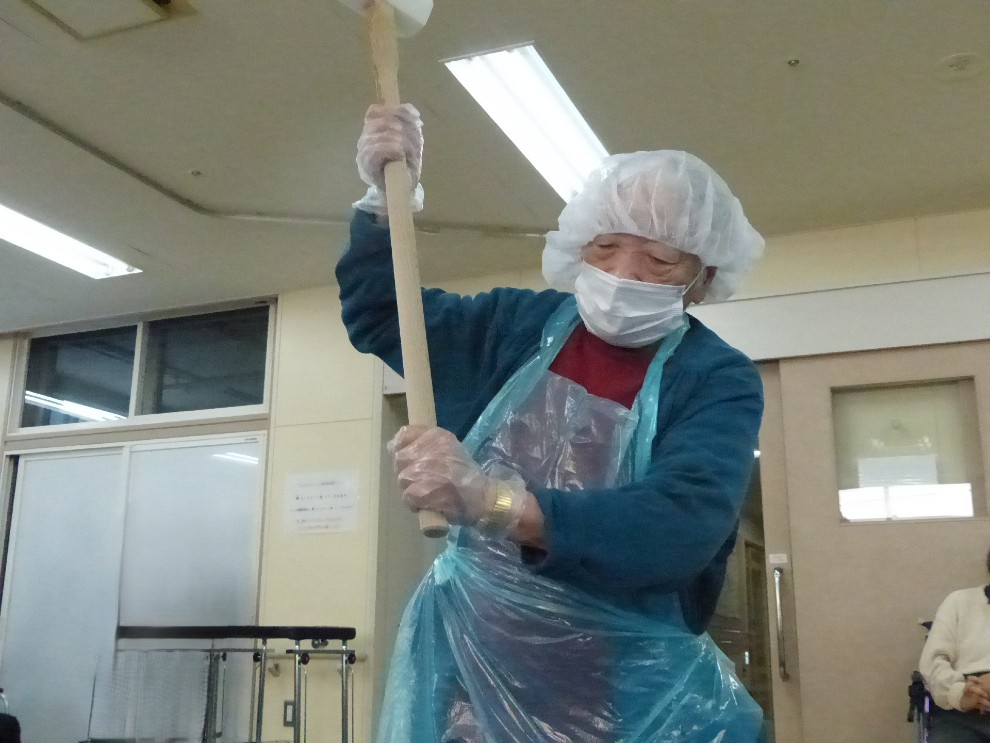 杵で餅をつく女性利用者様