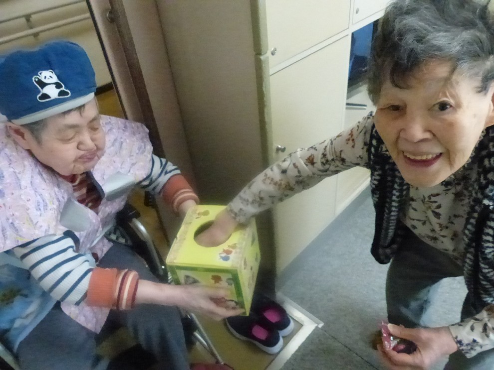 節分豆まきにて年女の利用者様から甘納豆を受け取り、笑顔の女性利用者様