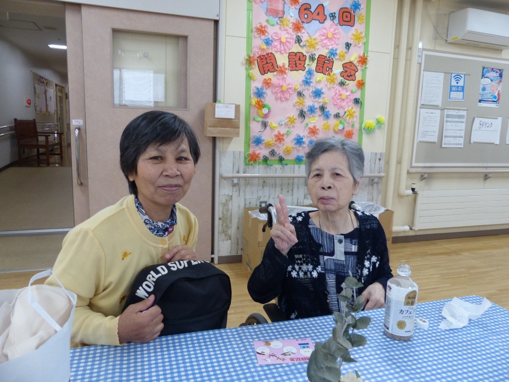 装飾された撮影スポットにてご家族様と記念撮影する女性利用者様