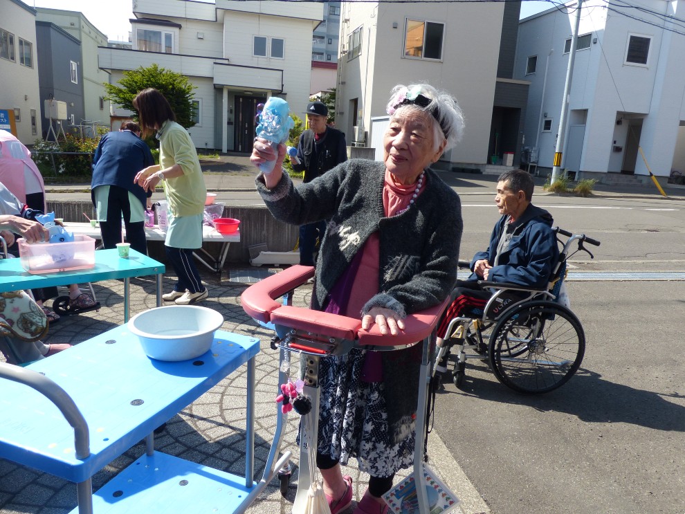施設の中庭でシャボン玉を楽しむ女性利用者様