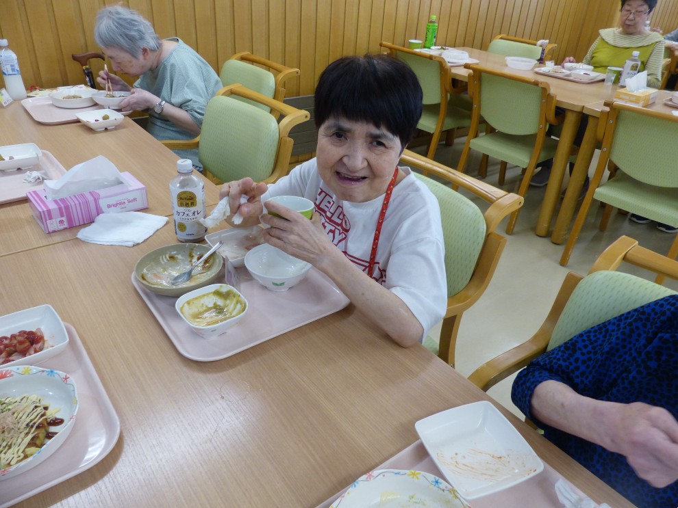 七夕まつりで提供した食事を前に笑顔の女性利用者様