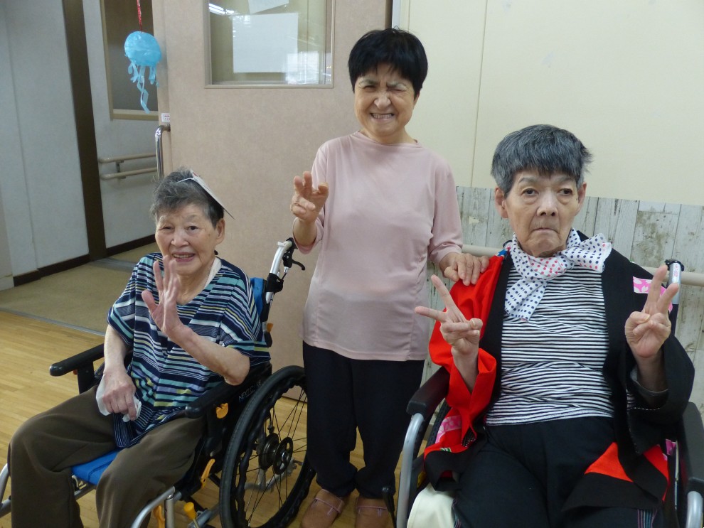 盆踊りで笑顔とピースサインで記念撮影をする女性利用者様たち