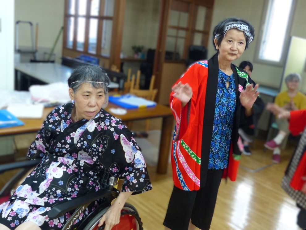 盆踊りで法被を着てリズムに合わせて踊る女性利用者様