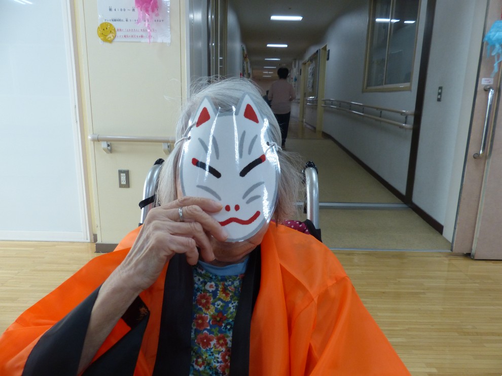 盆踊りで法被を着て狐のお面をつけている女性利用者様