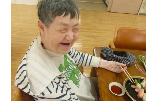 出前で頼んだ料理を前に笑顔溢れる女性利用者様