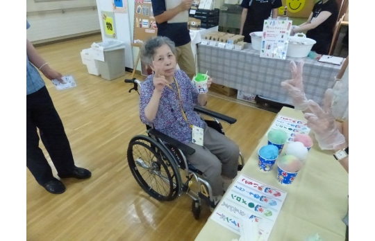七夕祭りで選んだかき氷を手にピースサインの女性利用者様
