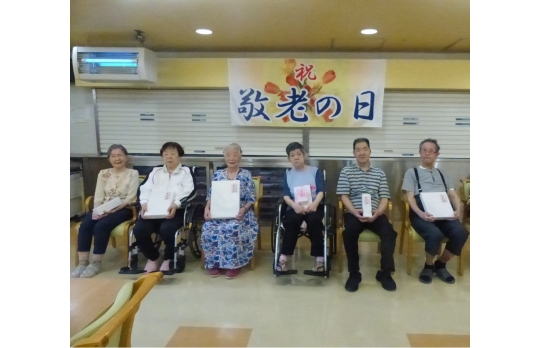 敬老会で長寿祝いを受ける利用者の皆さま